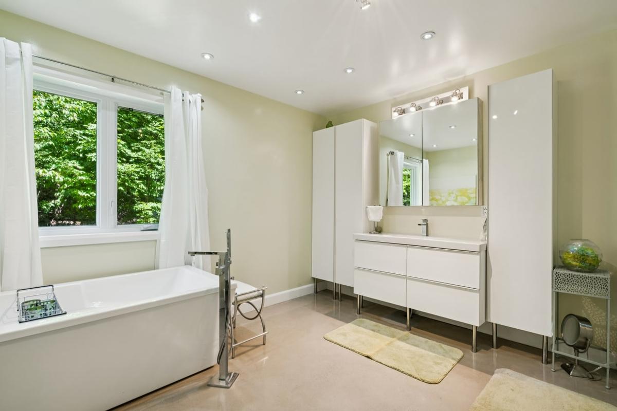 La salle de bain avec bain autoportant et douche vitrée