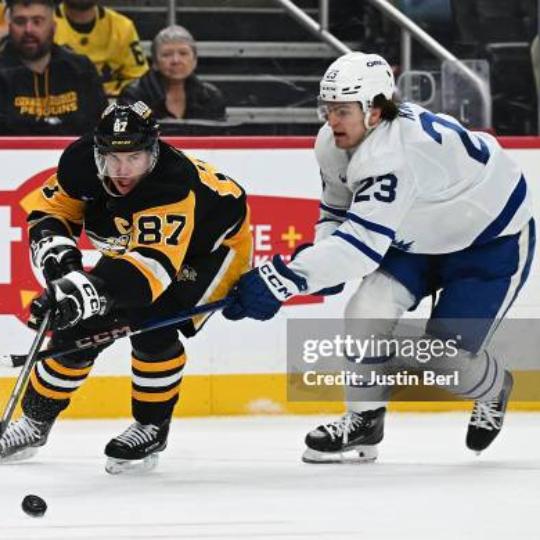 Sidney Crosby et Matthew Knies luttant pour la rondelle