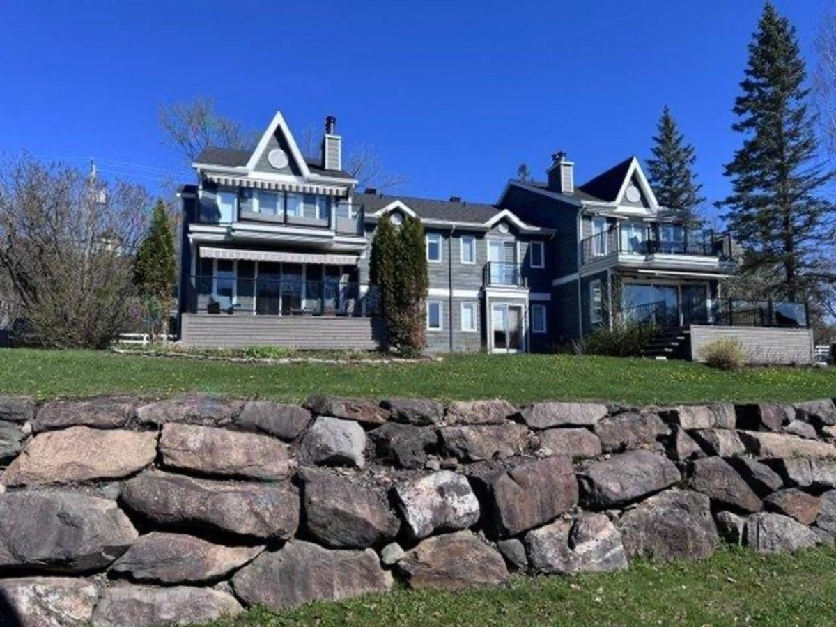 Vue extérieure du condo et de son environnement verdoyant