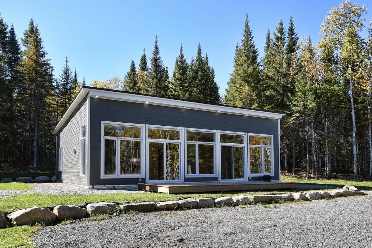 Façade de la propriété dans son environnement boisé