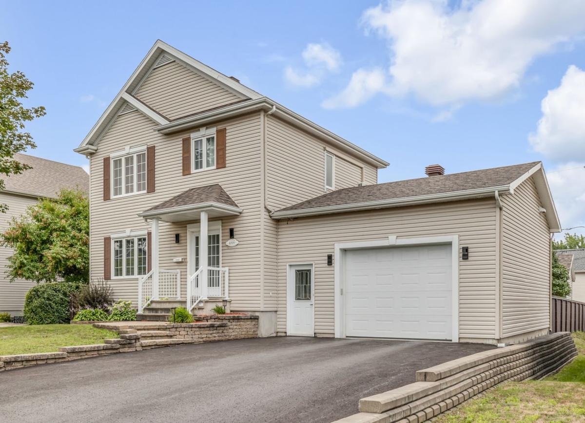 Façade du cottage avec entrée asphaltée et garage
