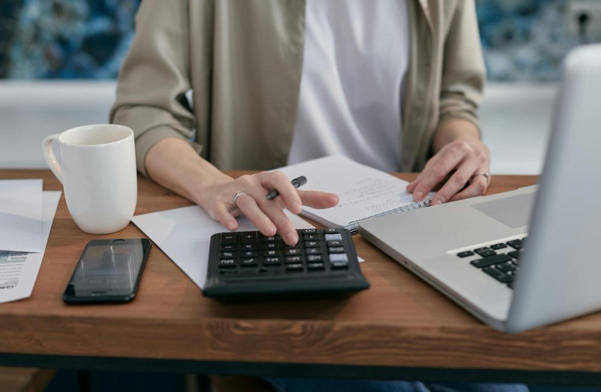 Pexels - Mikhail Nilov, personne avec une calculatrice et un ordinateur portable