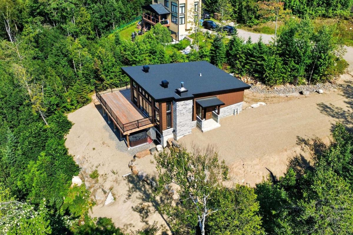 Vue aérienne montrant l'implantation de la maison sur le terrain boisé