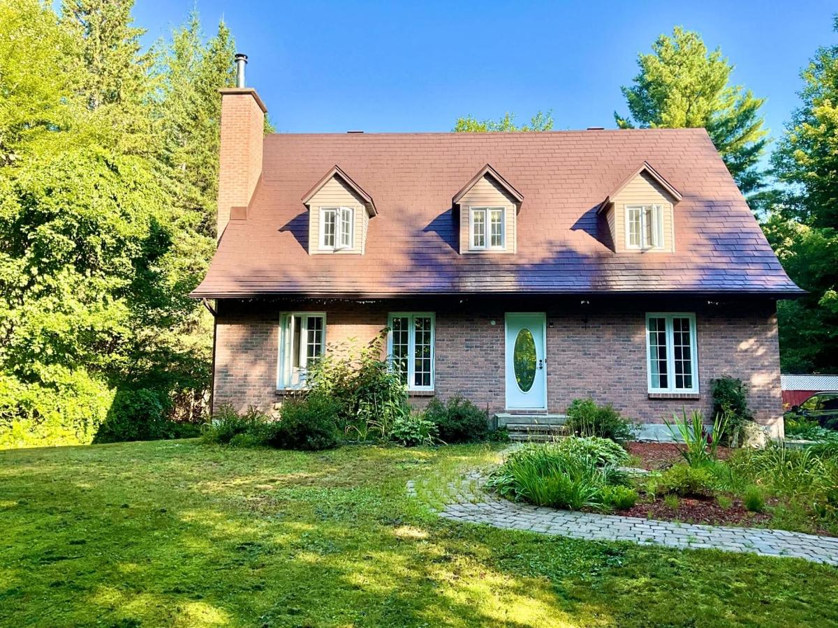 Façade du cottage entourée de verdure