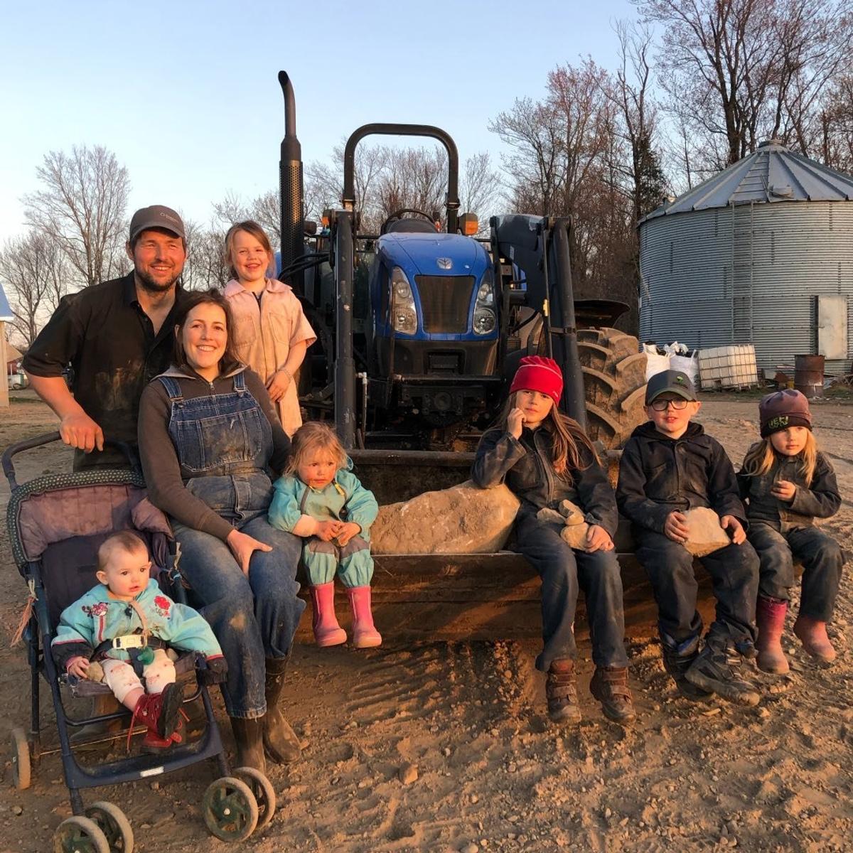 La famille devant leur tracteur au coucher du soleil